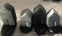 a group of black stones on a white surface