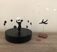 a small figurine of a cat and a star on top of a black plate