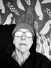 a black and white photo of a woman wearing glasses and a beanie