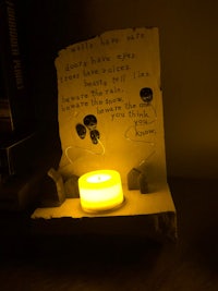 a candle lit on a piece of paper