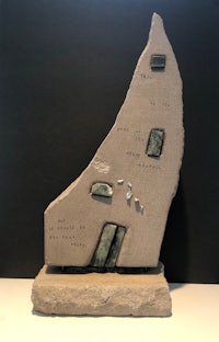 a sculpture of a house on a rock